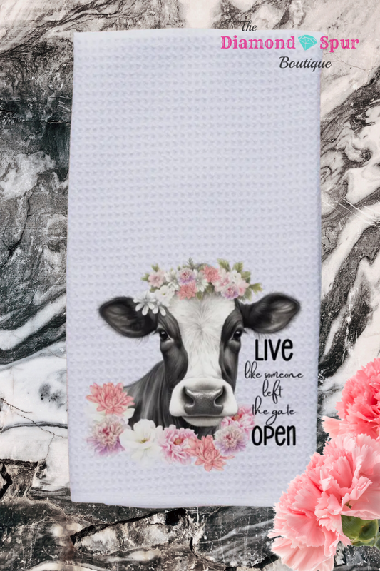 white waffle dish towel with cow and flowers that says live like someone left the gate open