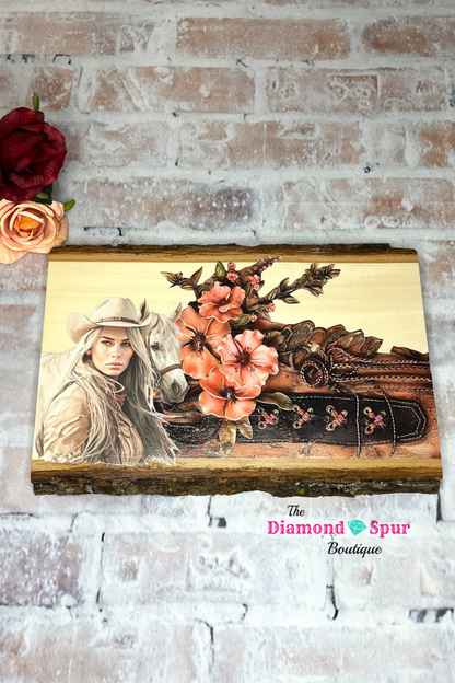 Natural wood plaque with a cowgirl, horse and floral leather picture on it